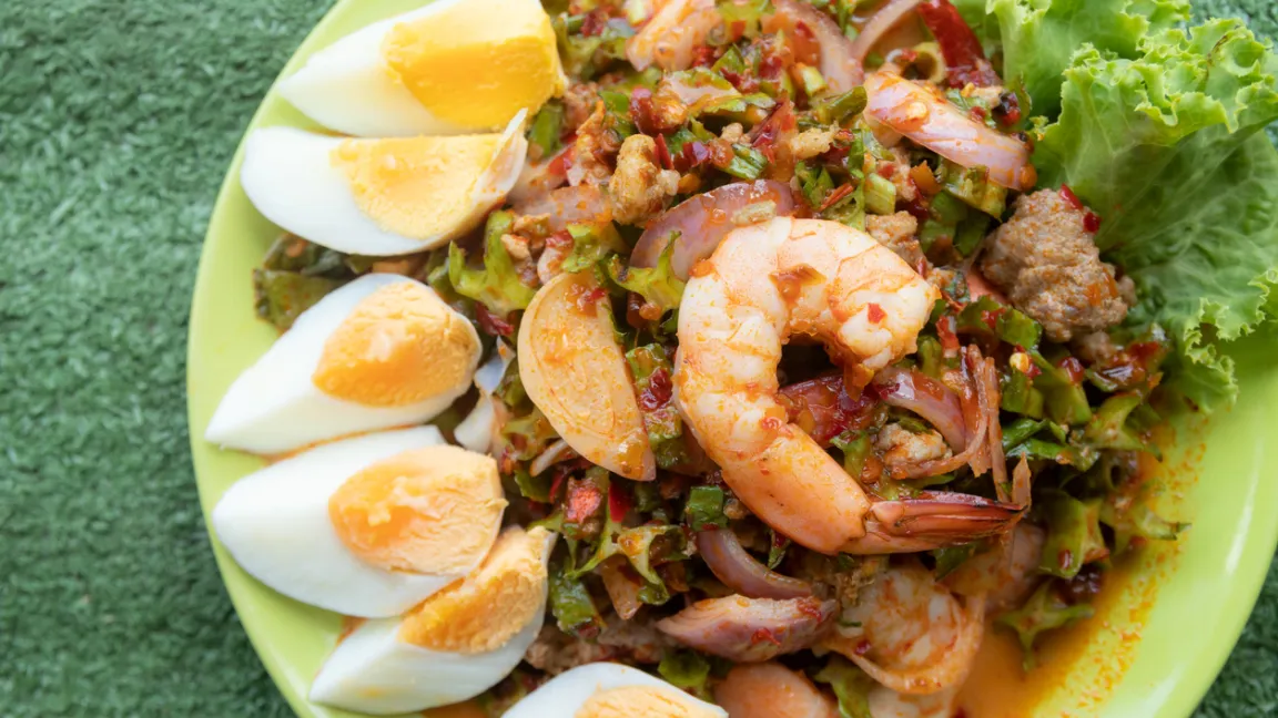 Thailändischer geflügelter Bohnengarnelensalat mit gekochten Eiern. Die quer geschnittenen Hülsen sind an der H-Form zu erkennen. Foto: iStock