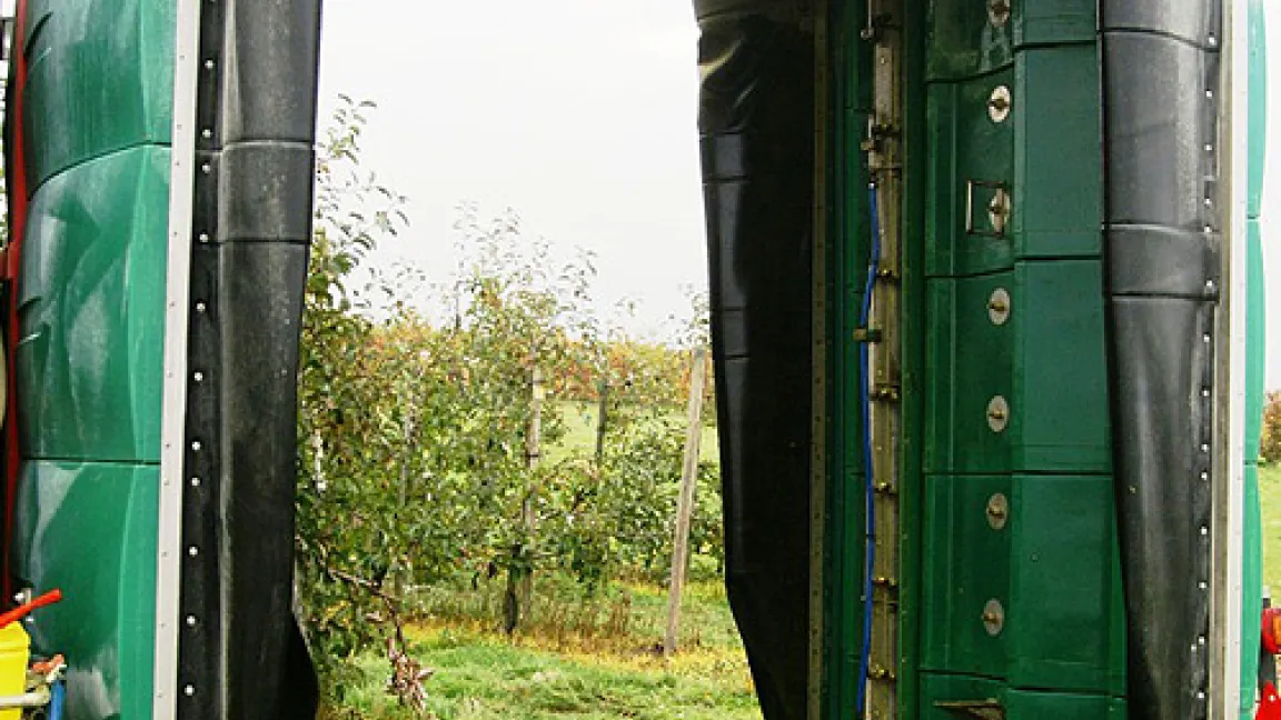 Sprühdüsen und Reflektorwände umgeben die Baumzeile wie ein Tunnel. Foto: Kompetenzzentrum für Obstbau Jork
